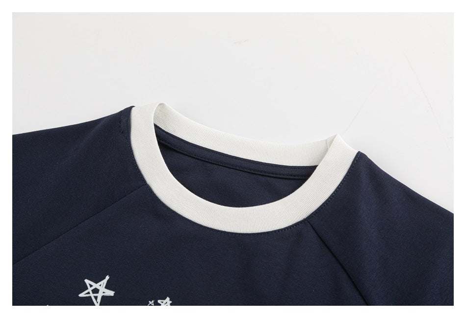 Close-up of the navy shirt's round cream ribbed neckline and shoulder seams.