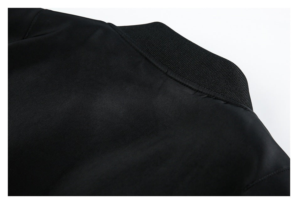 Close-up of a black garment with a wide ribbed collar and stitched seams.