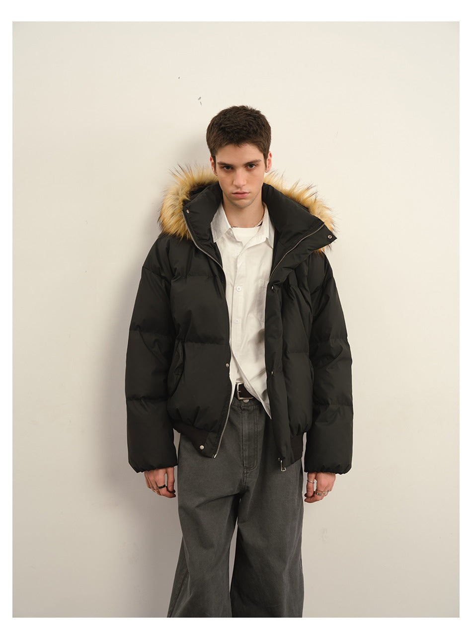 Man wearing a black fur-trimmed hooded puffer jacket, facing forward against a plain background.