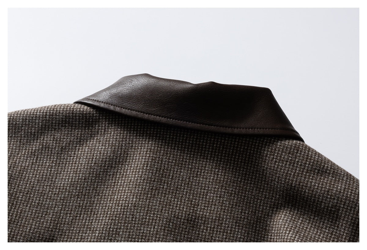 Close-up of a dark brown leather collar against brown and gray houndstooth fabric.