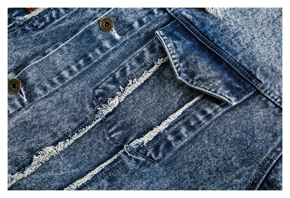 Close-up of an acid-wash denim flap pocket and distressed, frayed seam detailing.