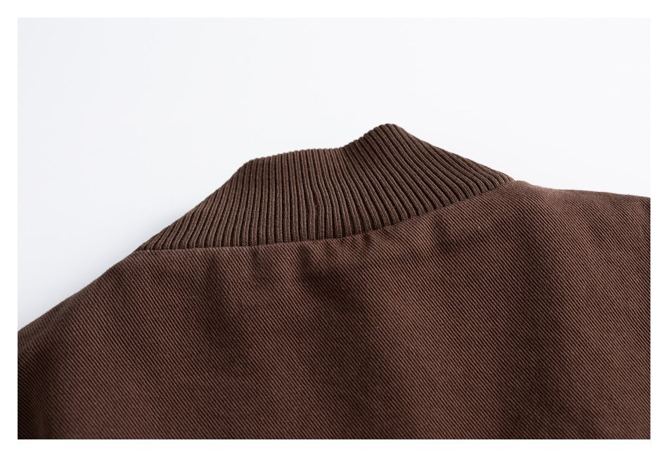 Close-up of the dark brown jacket's ribbed stand collar and back seam.