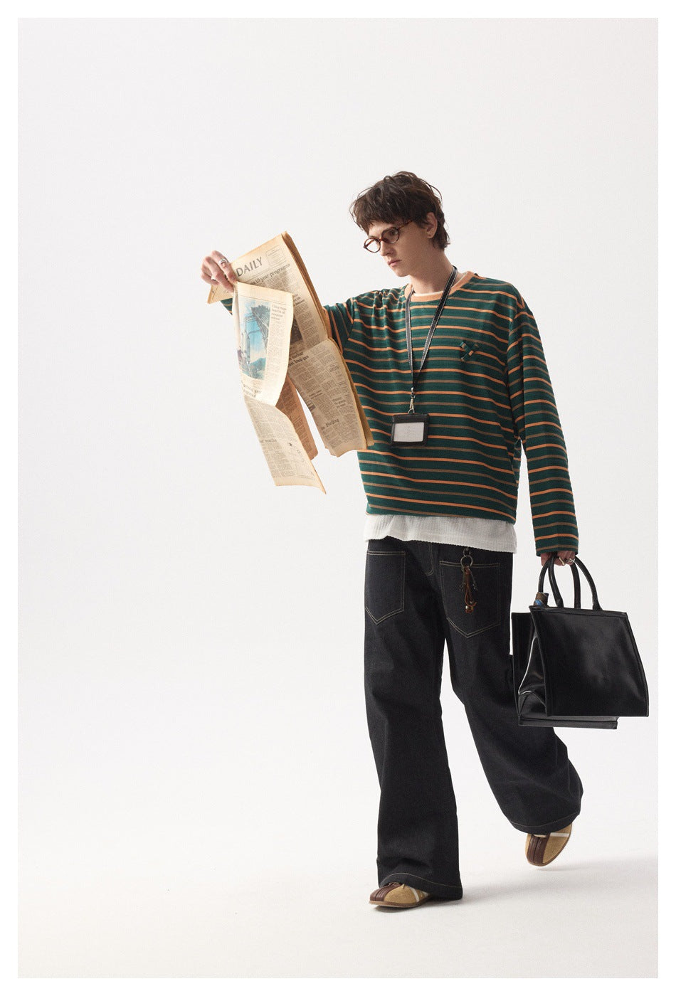 Model wearing a dark green and orange striped long-sleeve shirt with black wide-leg jeans.