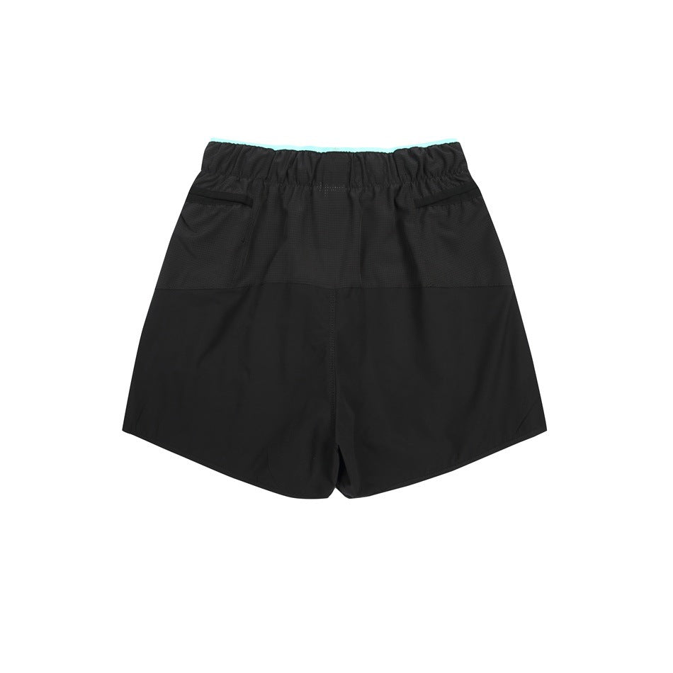 Back view of black shorts with an elastic waist, two rear pockets, and a narrow turquoise waistband accent.
