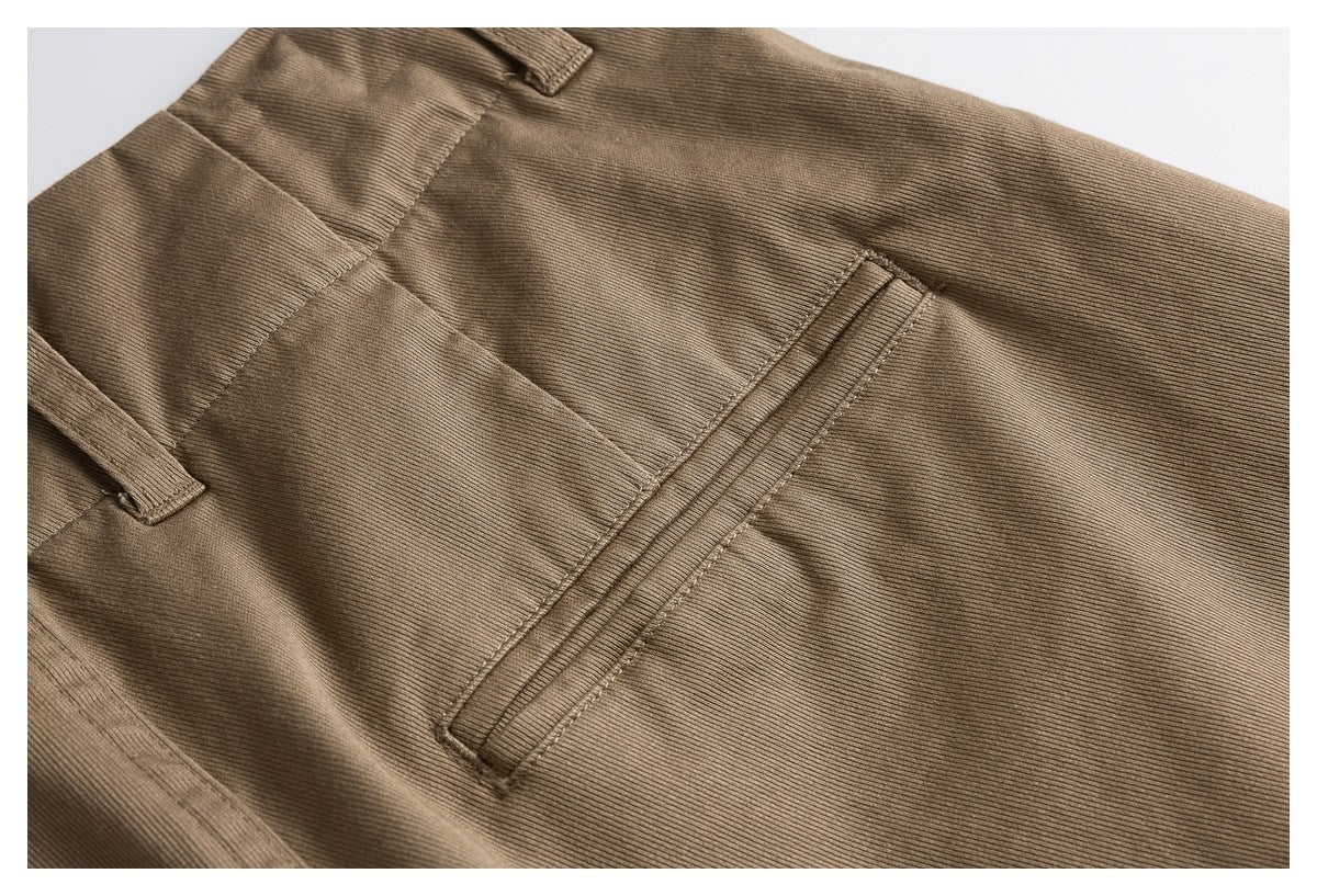 Close-up of a brown trouser welt pocket and surrounding stitching.