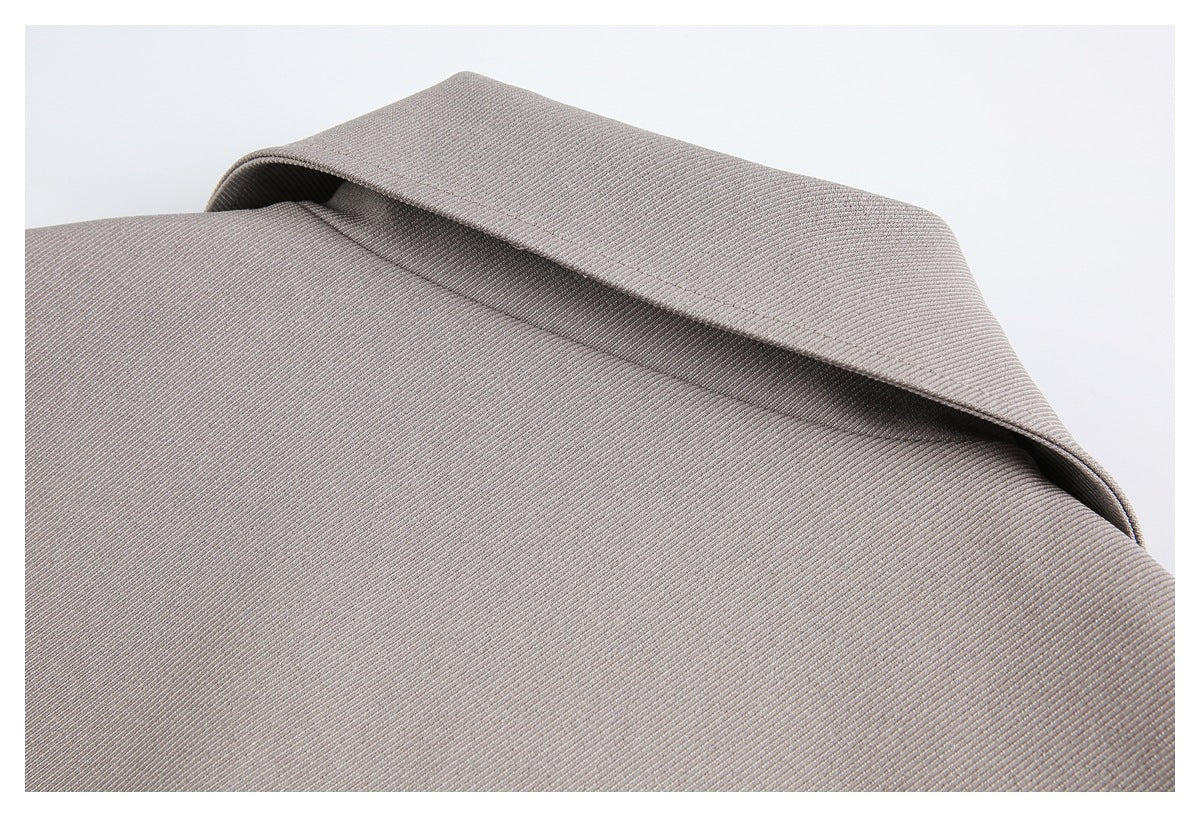 Close-up of the taupe-gray coat's folded collar and finely textured fabric.