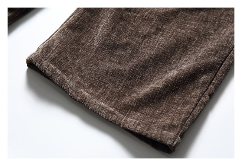 Close-up of the finished hem on brown crosshatched trousers.
