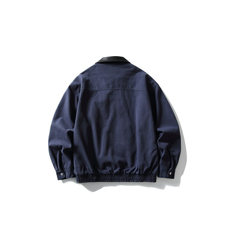 Back view of a navy jacket with a black collar, gathered elastic hem, and buttoned cuffs.