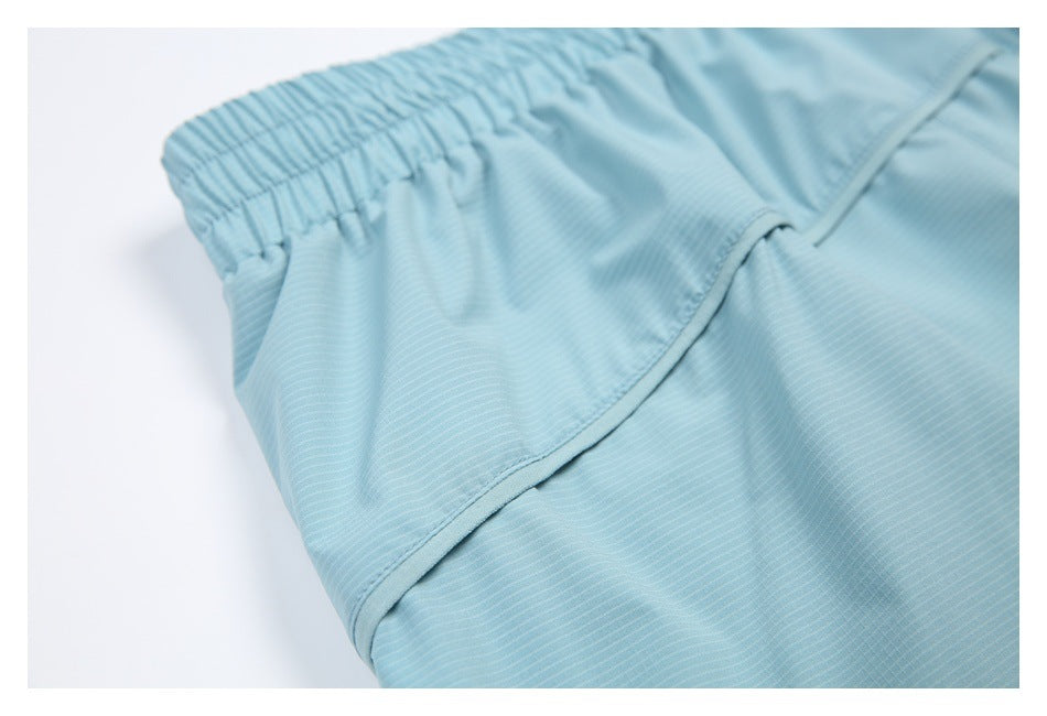 Close-up of pale blue garment fabric showing an elastic waistband and curved seam.
