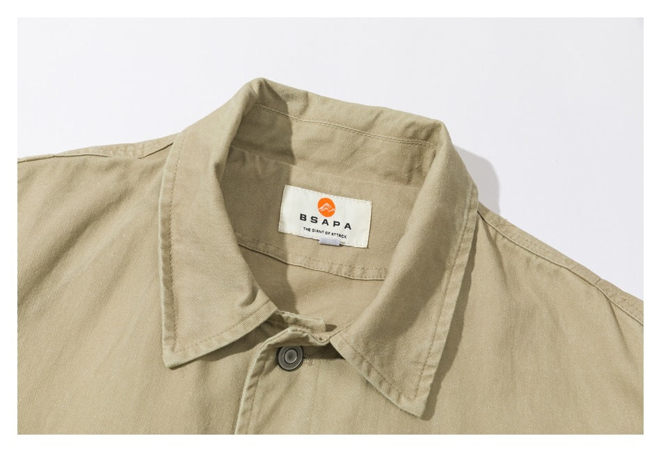 Close-up of a tan jacket collar, top button, and sewn neck label.