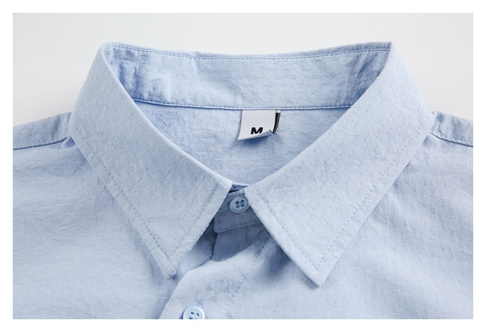 Close-up of a light blue shirt's pointed collar, top buttons, and M size label.