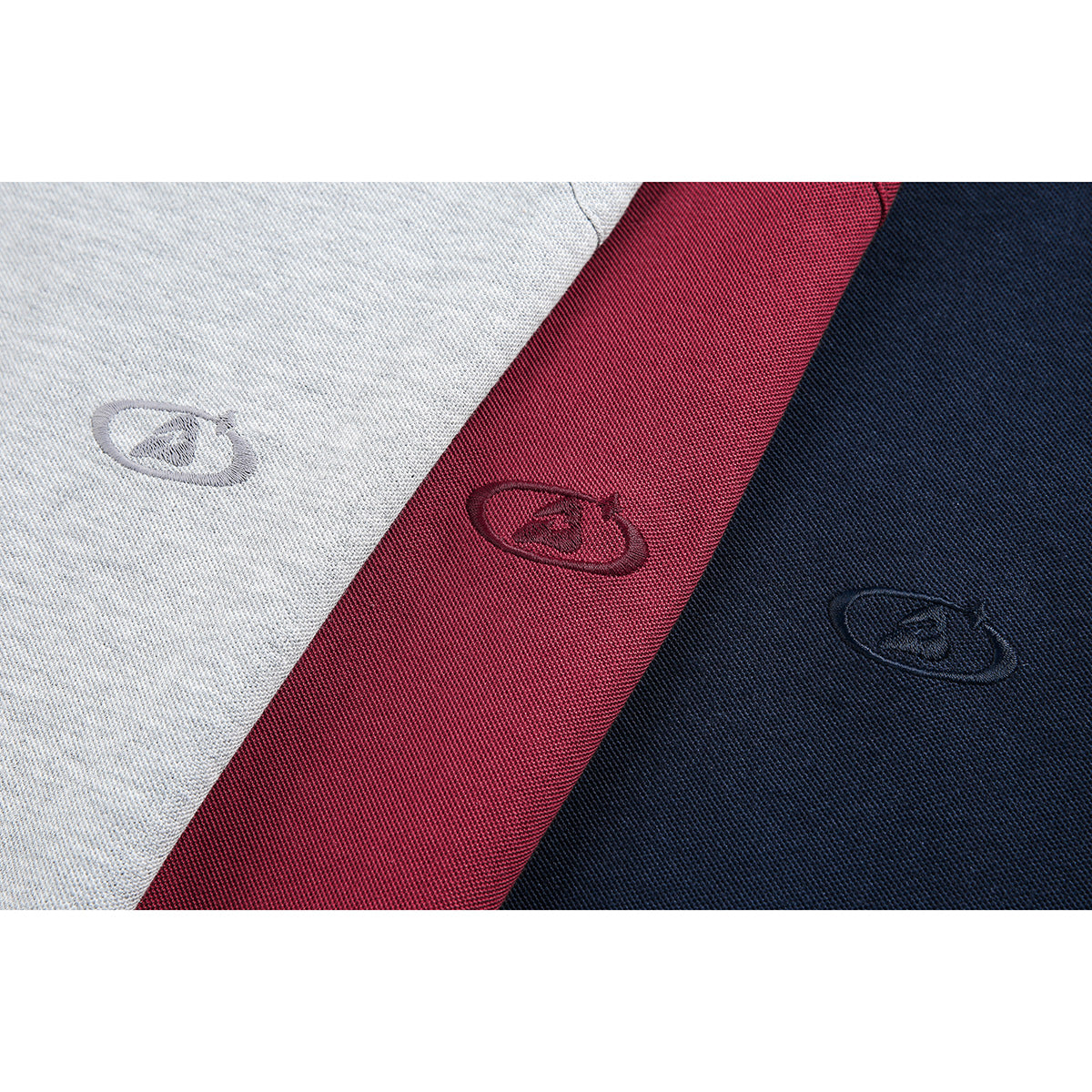 Close-up of embroidered oval emblems on light gray, burgundy, and navy polo fabric.