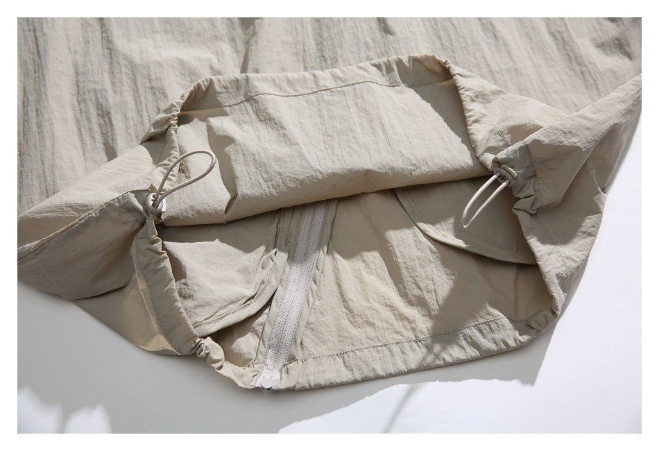 Close-up of the beige jacket opened to show its interior fabric, zipper, and drawcord details.