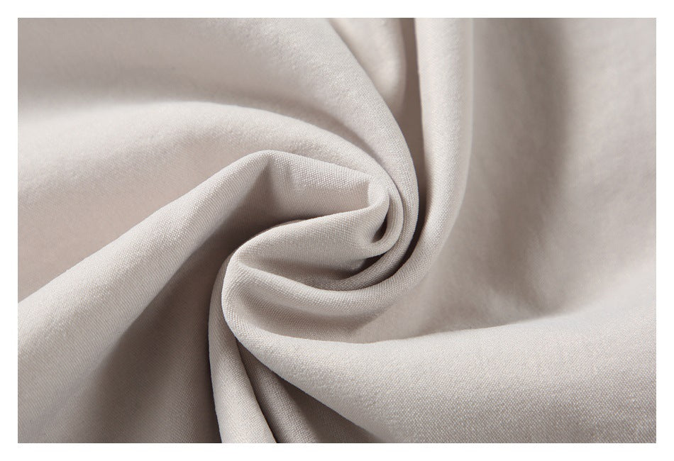 Pale beige garment fabric gathered into a swirl, showing its texture and drape.