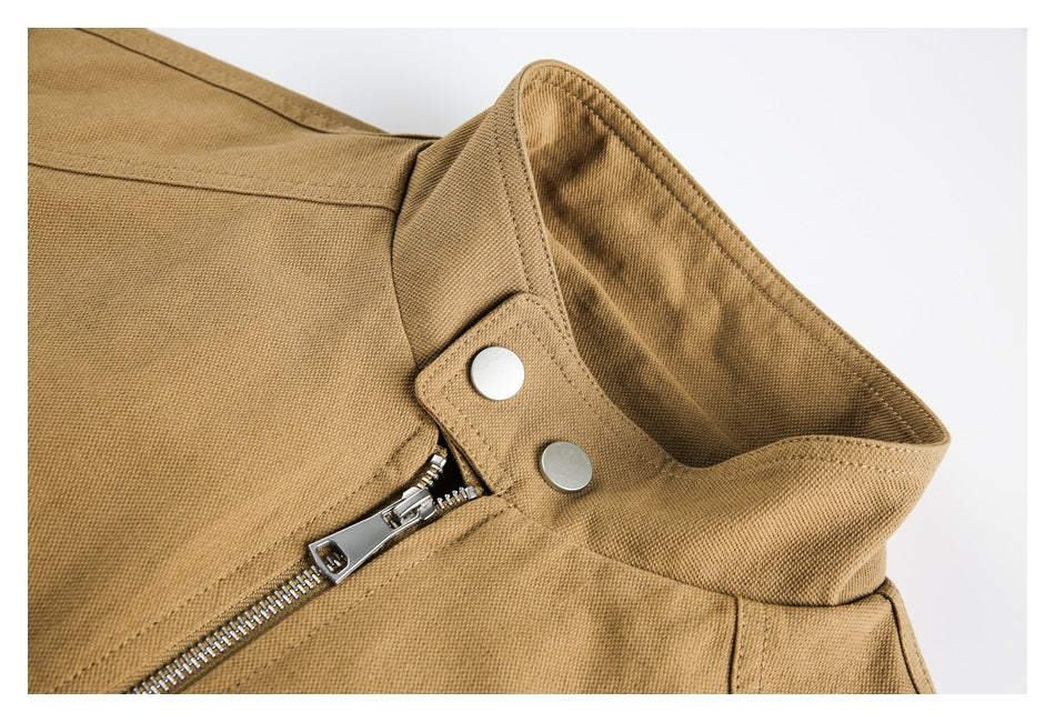 Close-up of a tan jacket's raised collar, silver snaps, and front zipper.