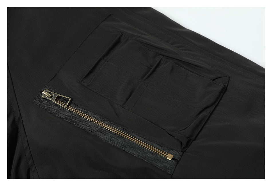Close-up of a black garment pocket with a brass-tone zipper underneath.