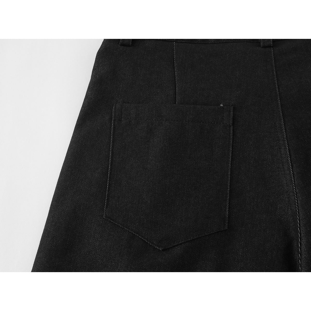 Close-up of black shorts showing a large back patch pocket and seam details.