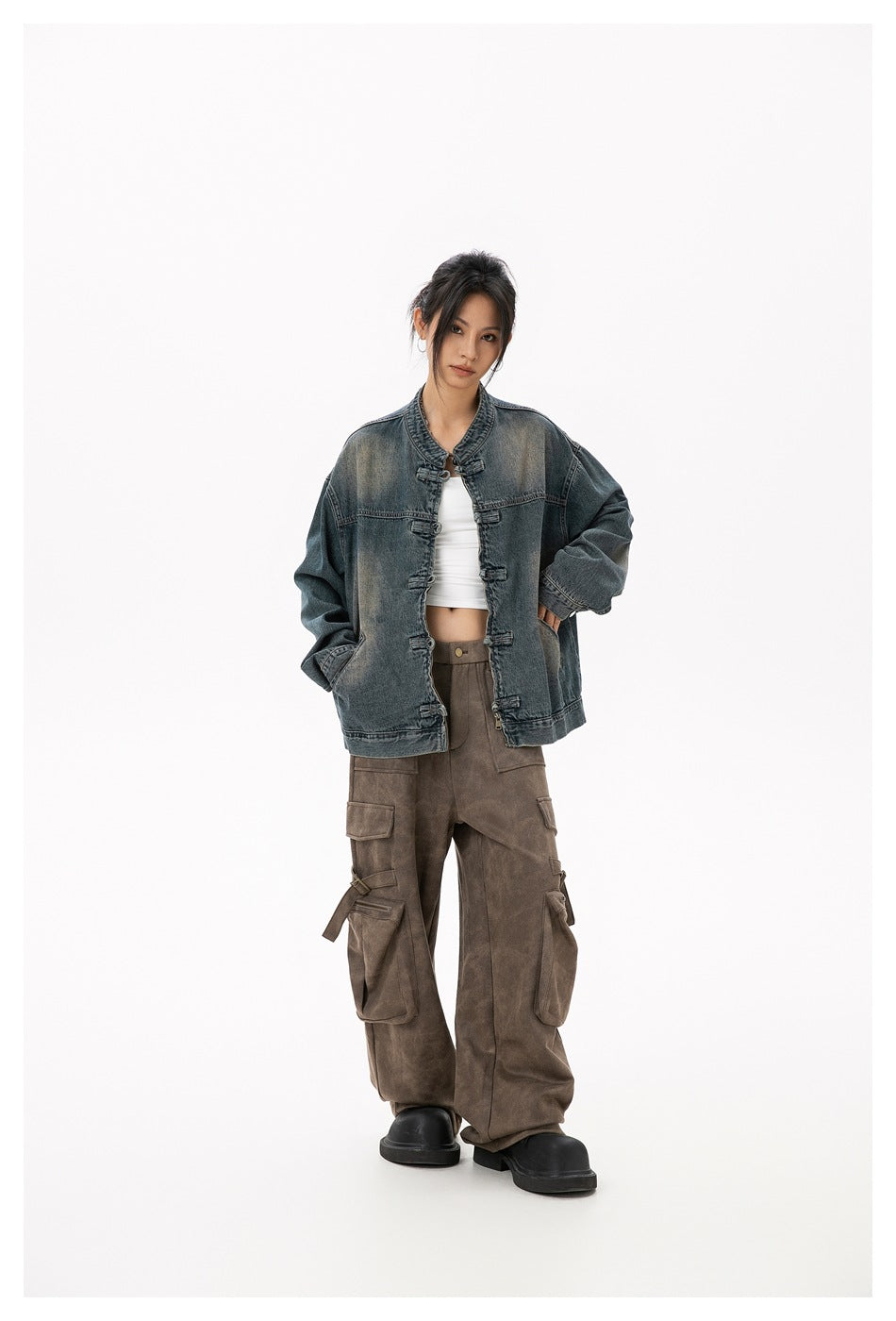 Full-length model wearing a relaxed faded blue-gray denim jacket with frog closures and large sleeves.