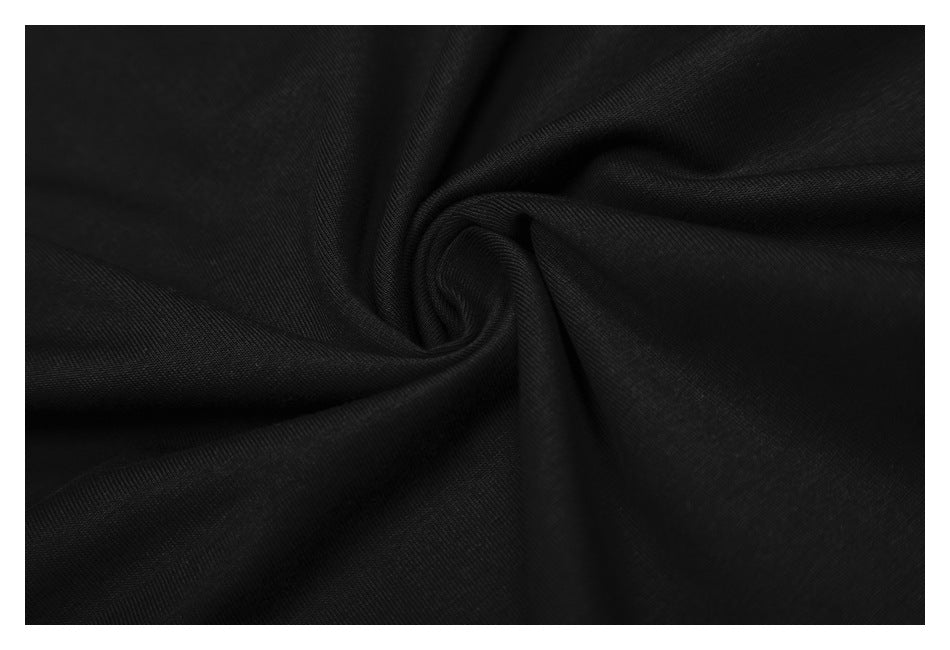 Close-up of black fabric gathered into folds, showing its surface texture.