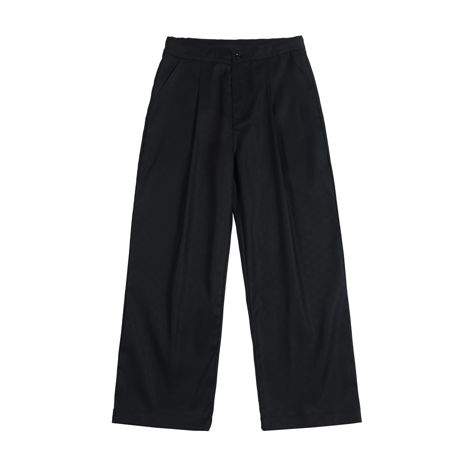 Front view of black wide-leg trousers with a button closure, pleats, and slanted pockets.
