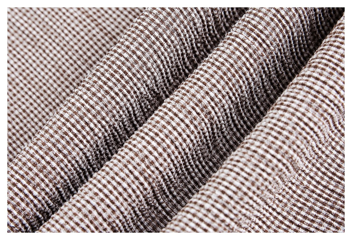 Close-up of brown and cream small-check fabric gathered into soft folds.