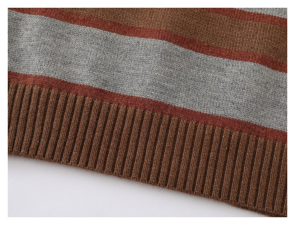 Close-up of the sweater's striped knit body and wide ribbed brown hem.