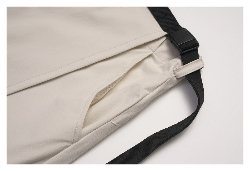Close-up of the beige wrap skirt's overlapping panels and black adjustable strap with buckle.