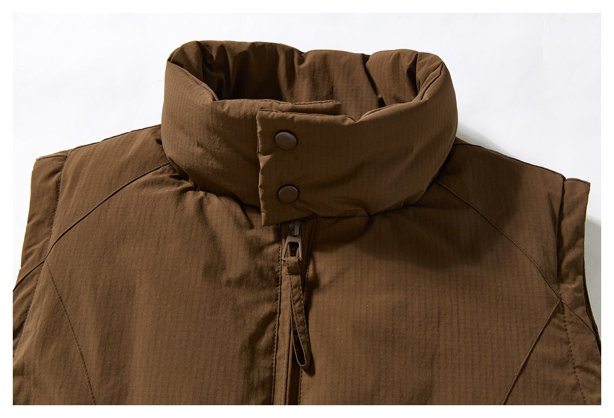 Front close-up of a brown jacket's tall padded collar, two snap buttons, and central zipper.