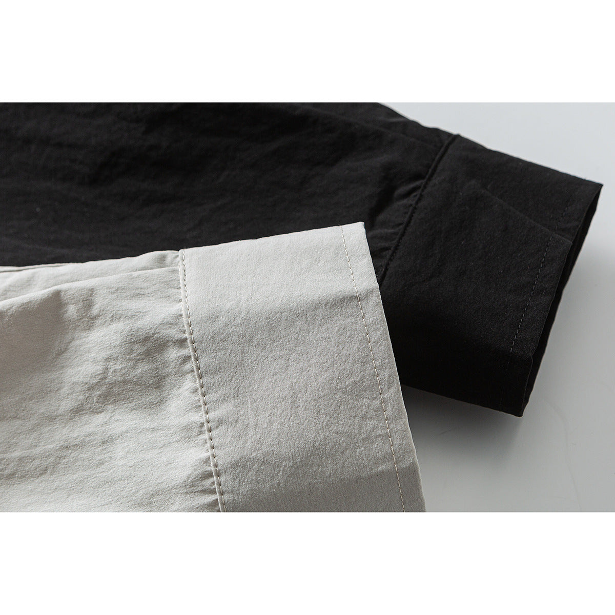 Close-up comparison of light beige and black overshirt sleeves and cuffs.