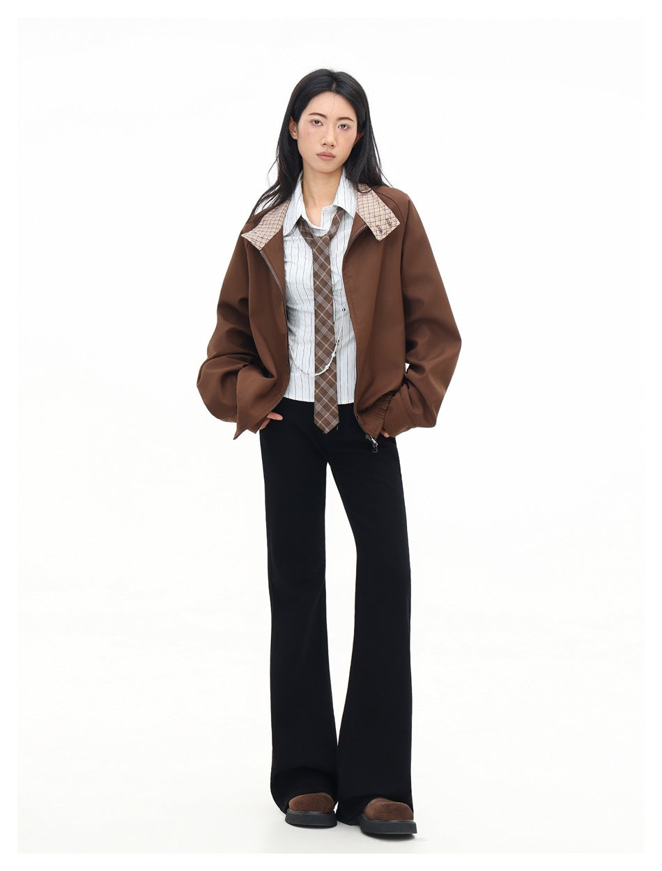 Full-length view of a model wearing an open brown jacket with plaid collar accents, striped shirt, plaid tie, and black