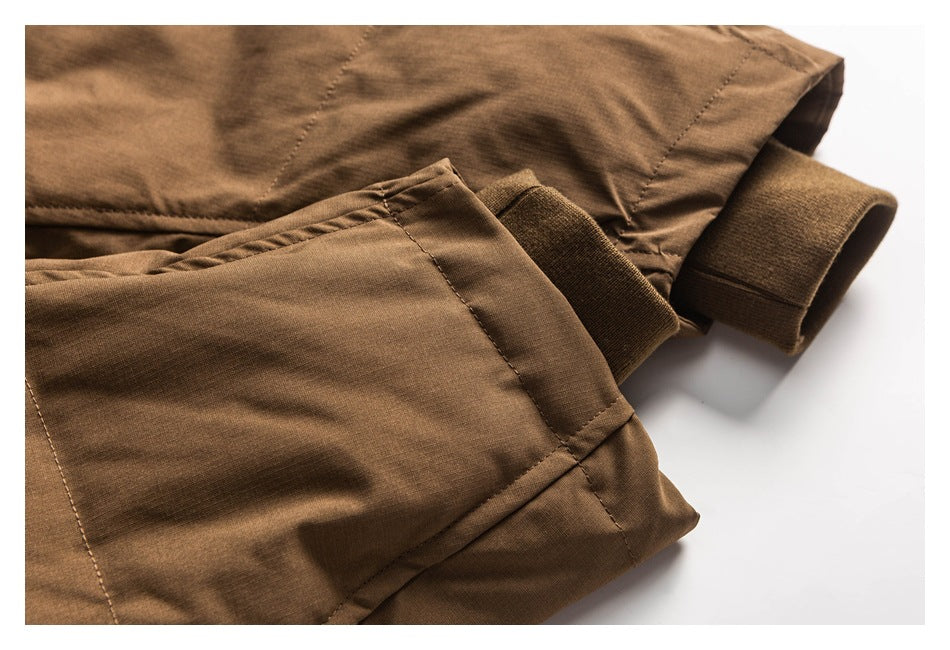 Close-up of a brown jacket's stitched edge and ribbed cuff.