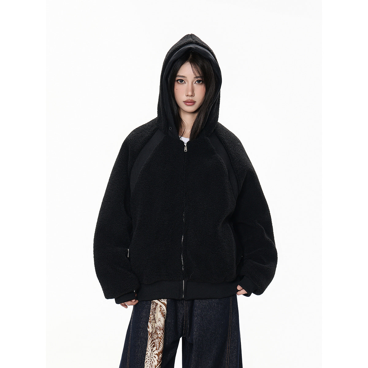 Model wearing a black hooded zip-up jacket with ribbed cuffs and hem, shown from the front.