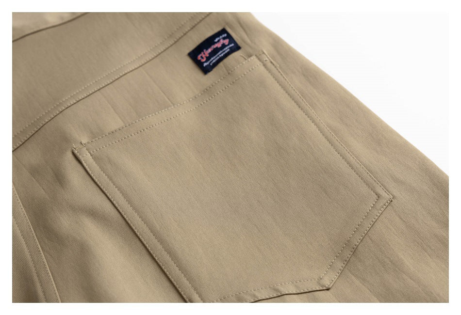 Close-up of a tan trouser back pocket and a small sewn label at the waistband.