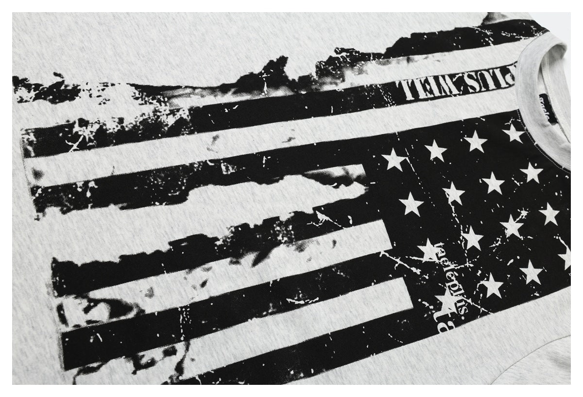 Close view of a light heather gray T-shirt front with a distressed black-and-white flag and star graphic.
