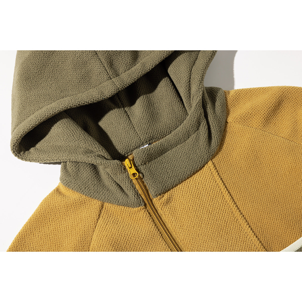 Close-up of an olive hood and mustard pullover jacket with a short gold front zipper.