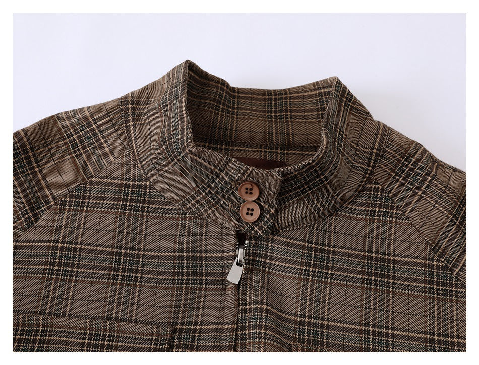 Close-up of a brown plaid jacket collar with two buttons and a silver zipper pull.
