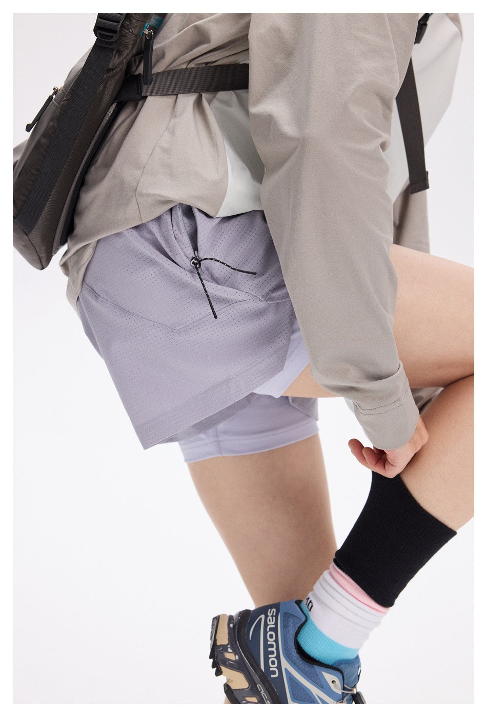Close-up of the lavender shorts’ side and rear, showing the perforated fabric, zippered pocket and inner liner.