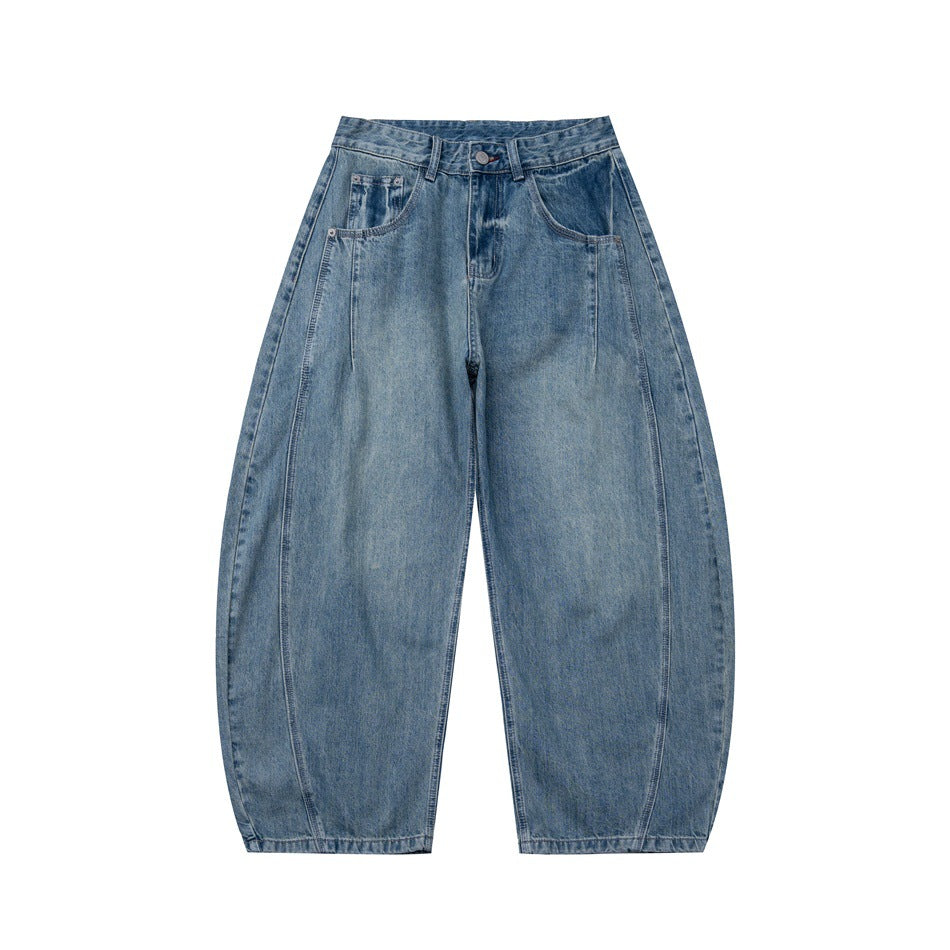 Front view of blue washed denim wide-leg barrel jeans with curved leg seams and pockets