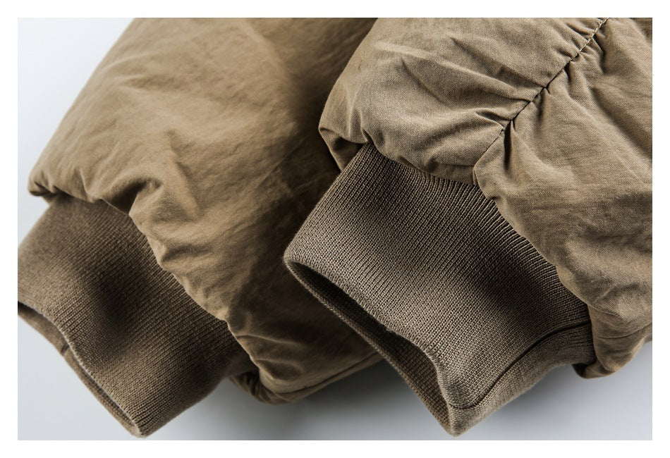Close-up of the tan coat’s sleeves and dark ribbed cuffs.