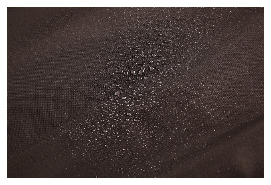 Close-up of dark brown fabric with water droplets beading on its surface.
