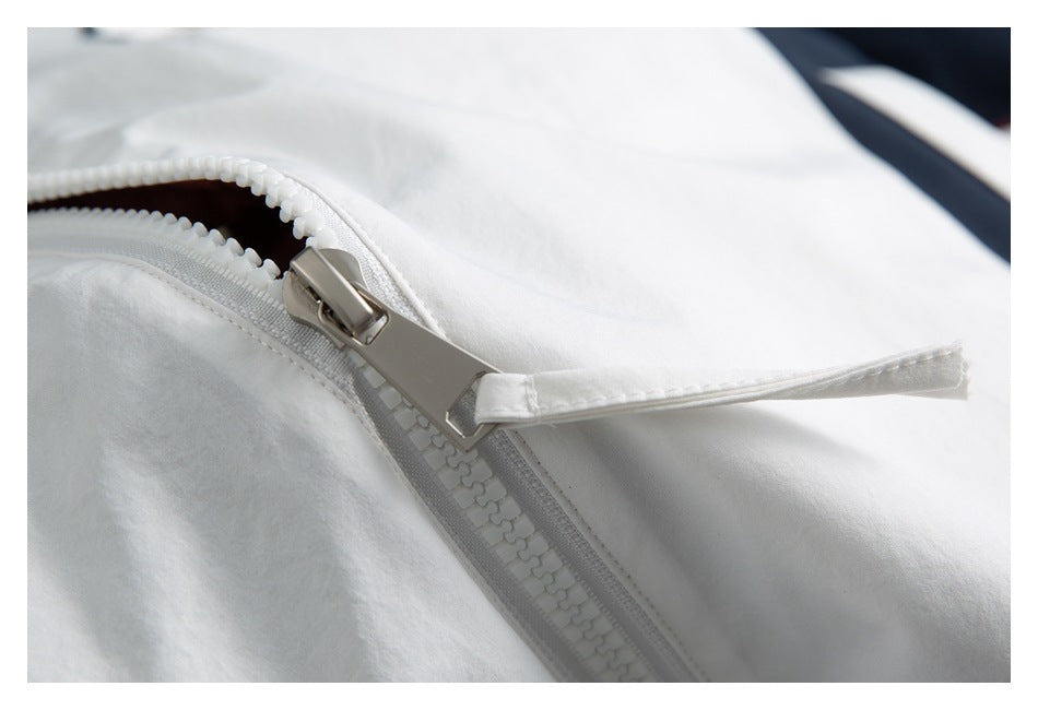 Close-up of a large white jacket zipper with a metal pull and matching fabric tab.