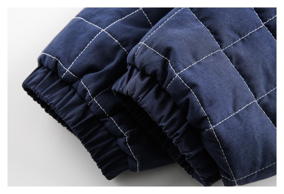 Close-up of navy quilted garment showing gathered elastic cuffs and light contrast stitching.