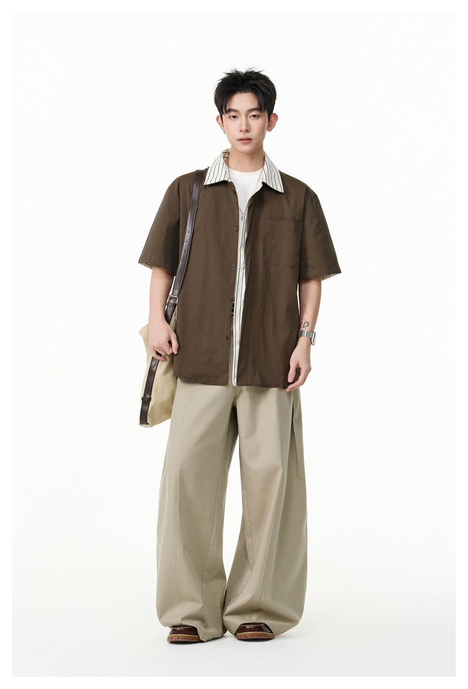 Model wearing a dark brown short-sleeve shirt with a striped collar, layered over a white tee.