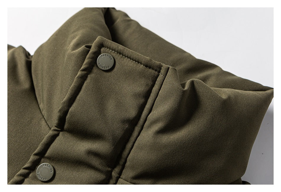 Close-up of an olive garment flap with two snap buttons embossed with the word “FASHION.”