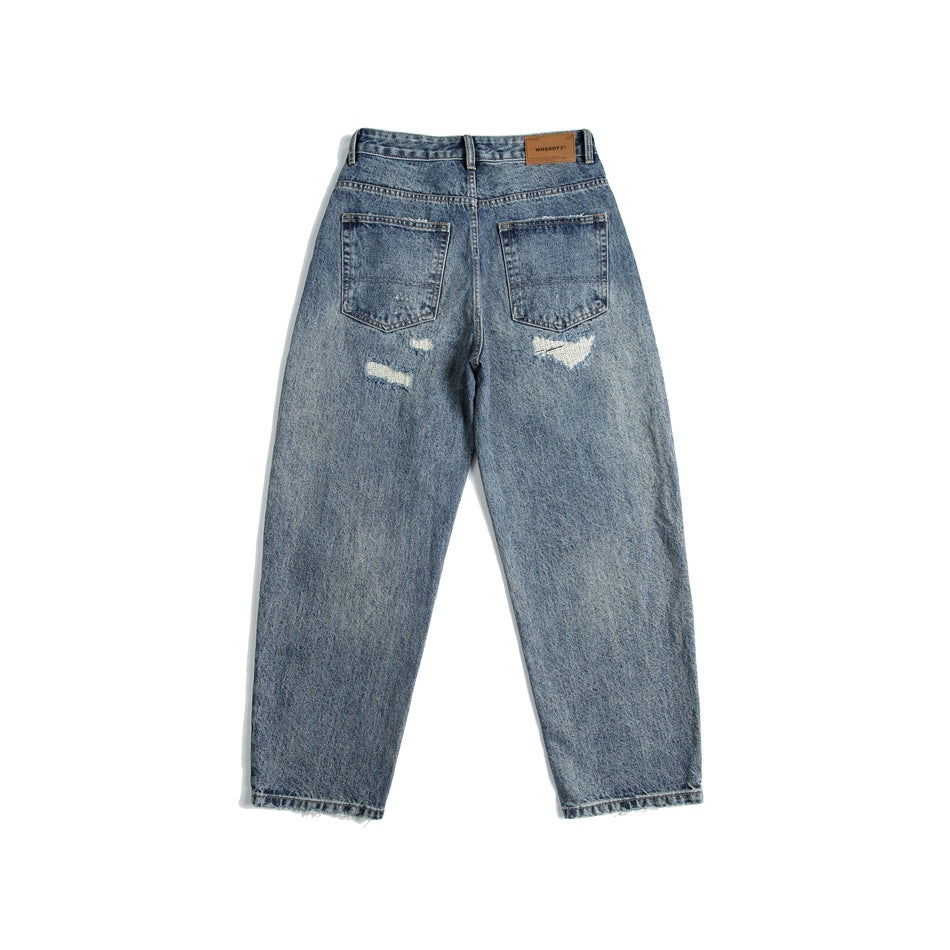 Back view of blue washed distressed jeans with two patch pockets, ripped details and a waistband patch
