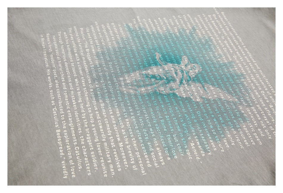 Angled close-up of white and teal English text printed on gray fabric.