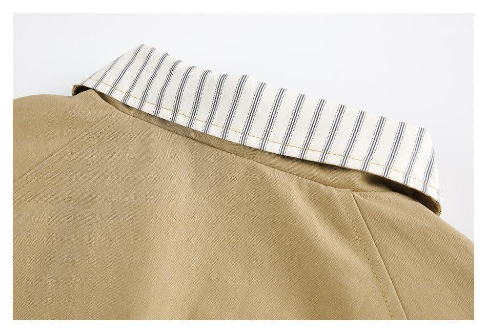 Close-up of a tan garment with a white collar lining patterned with narrow dark and tan stripes.