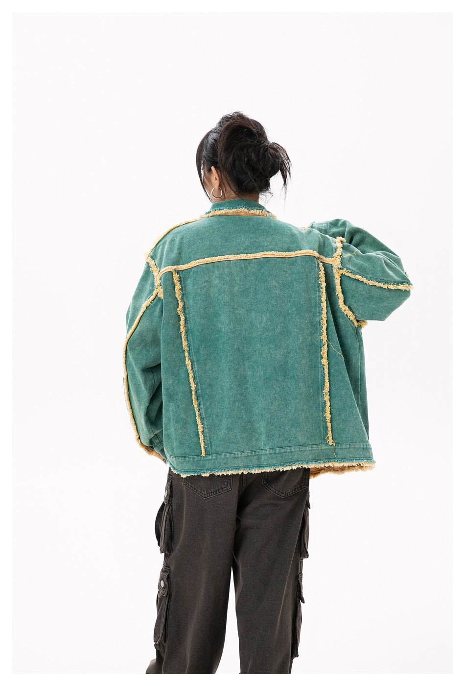 Back view of a model wearing a teal jacket with yellow frayed trim and a large plain back panel.
