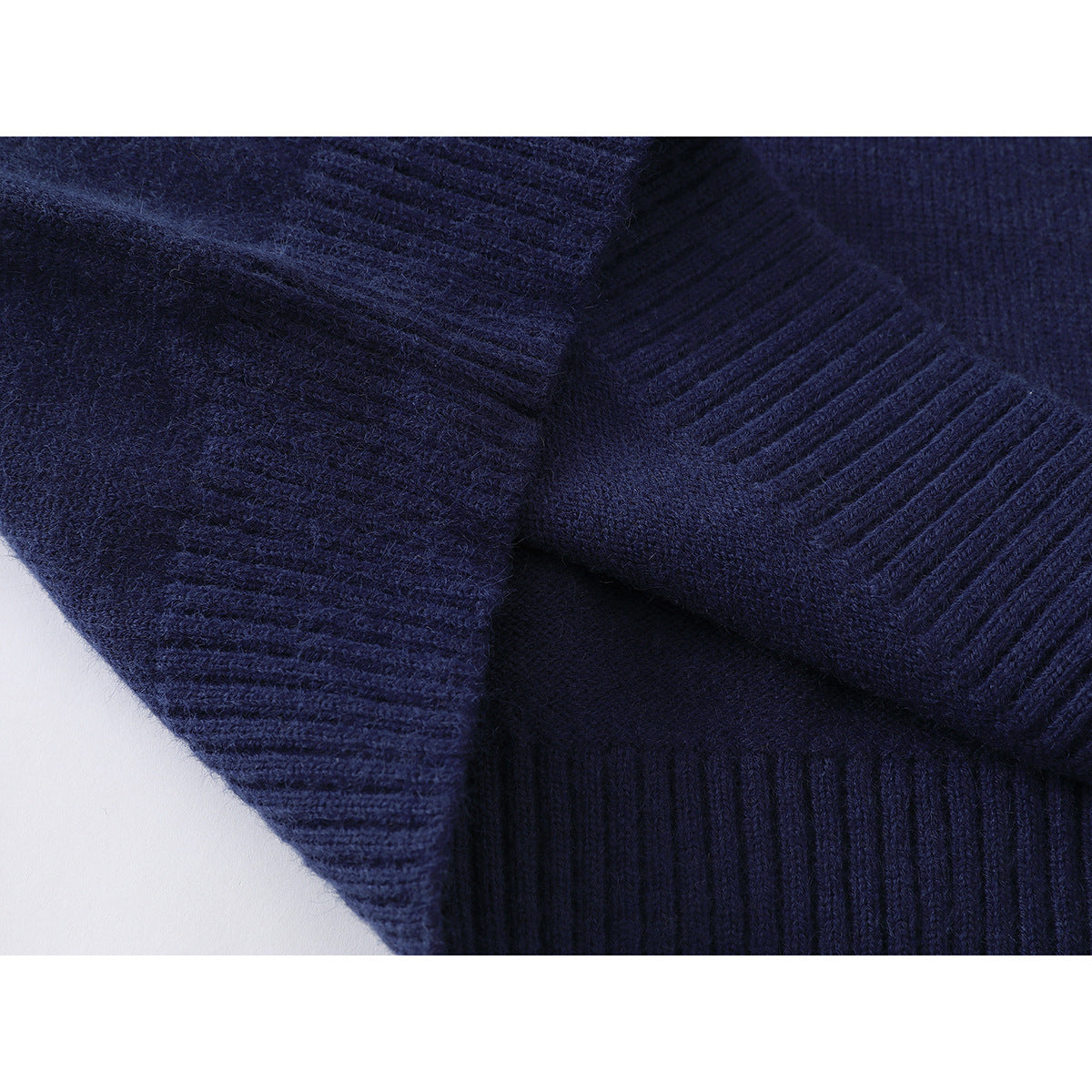 Close-up of navy knitted fabric with ribbed edges and a seam.