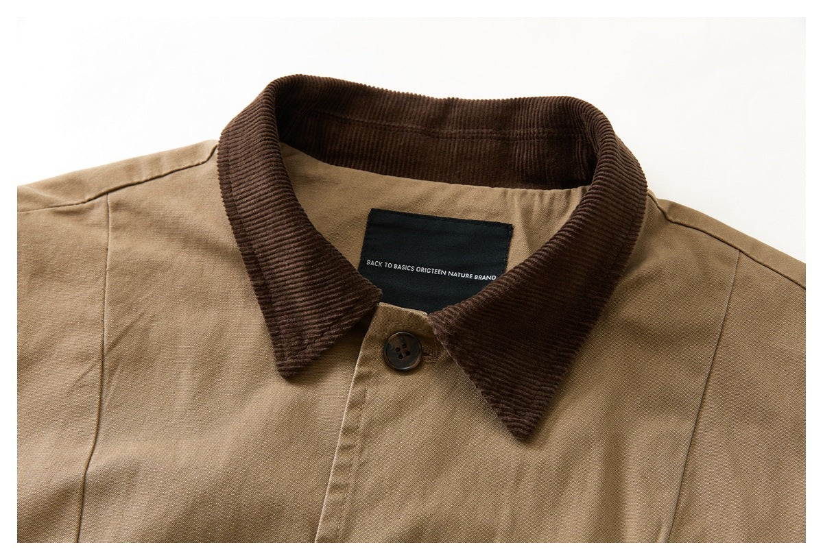 Close-up of a tan vest's dark brown corduroy collar, top button, and black neck label.